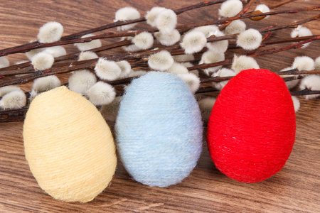 复活节的柳絮和鸡蛋包裹在乡村板上的羊毛串, 节日装饰