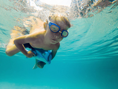 儿童男孩游泳水下泳池, 微笑着, 屏住呼吸与游泳眼镜