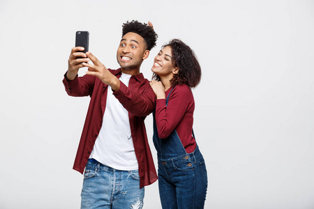 年轻漂亮的非洲裔美国人夫妇的姿势自拍姿态与智能手机