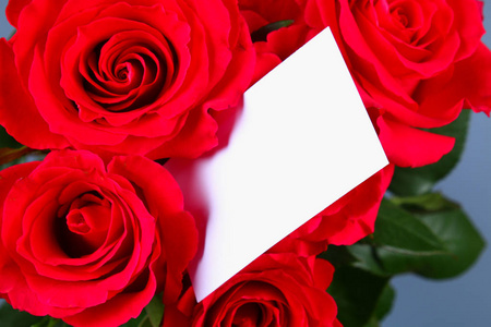 空白白礼品卡在床上的红色的玫瑰花瓣，准备好您的消息
