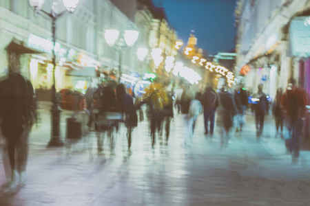 城市街道上步行的人无法辨认的剪影的抽象形象晚上, 夜生活。城市现代背景运动效应