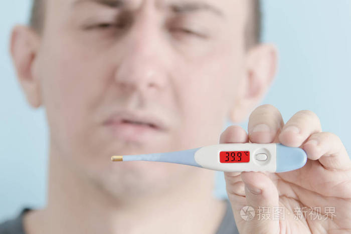 手里拿着温度计的人.体温升高