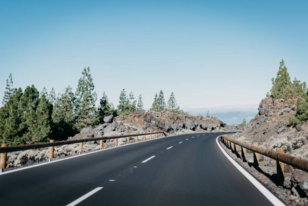 高速公路穿过岩石与 o 许多绿色松树树的权利附近的云。Teide 国家公园。特内里费