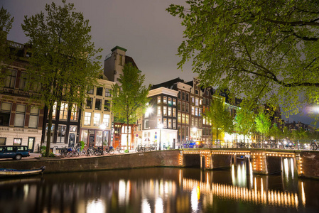 阿姆斯特丹城市夜景与运河, 桥梁和中世纪的房子在黄昏暮光照亮。荷兰阿姆斯特丹