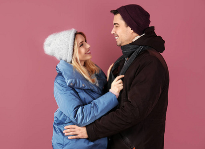 年轻夫妇在温暖的衣服颜色背景。准备寒假
