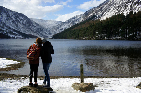 两个人在山上的湖岸边。上部 Lake.Glendalough.Wicklow 山. 爱尔兰