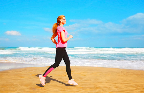 健身的年轻女子是运行夏季沿海滩附近的 s