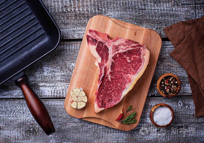 生的t骨牛排和铁烤盘