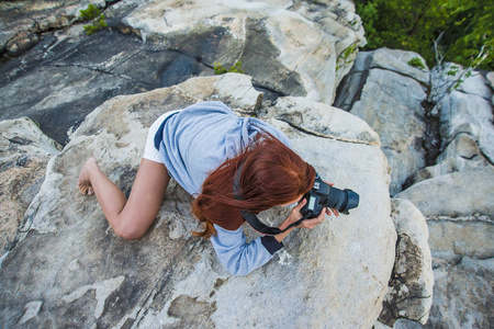 红发女摄影师正在拍摄山背景照片