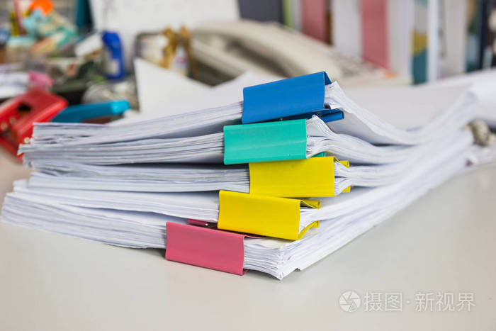 档案文件中的一叠纸在办公室的办公桌上有回形针商业概念