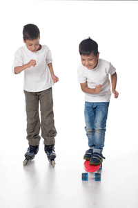 两个男孩骑轮滑鞋和一块木板