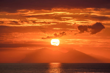 美丽的金色橙色日落在海洋。太阳把天空变成黄色, 橙色和红色色调, 在海洋中反射