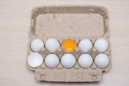 鸡蛋放在鸡蛋盘里, 一个鸡蛋裂开了。白色新鲜蛋小组