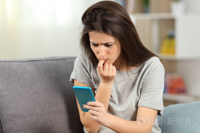 紧张的女孩咬指甲阅读手机内容
