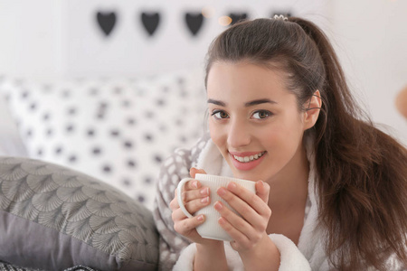 家中有杯热茶的美丽年轻女子