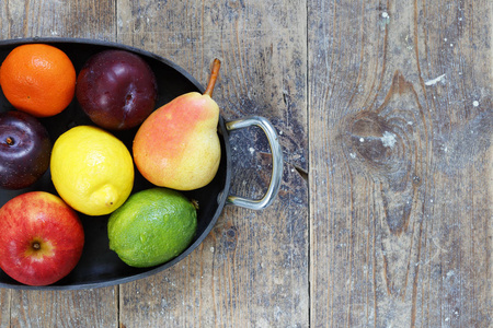 木桌上的苹果石灰柠檬梨李子混合果实, 复制空间权
