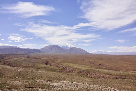 干旱的阿塔阿塔沙漠地形和积雪覆盖安第斯山脉山峰