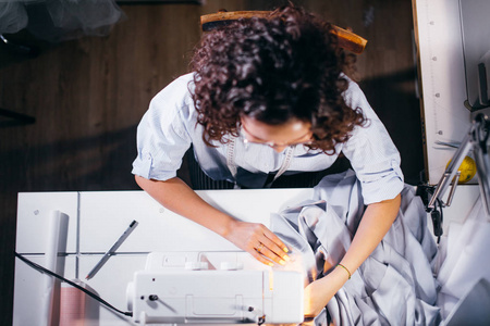 前穗高坐在缝纫机前和工作的裁缝高视图镜头照片