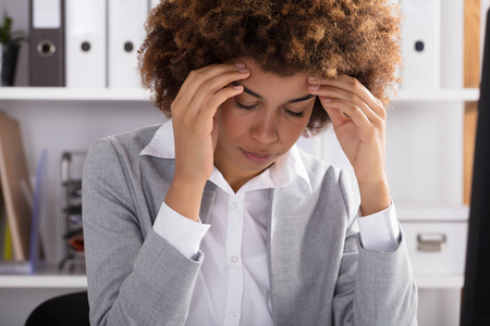 美国黑人女实业家在办公室头疼的画像