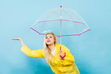 女人穿着雨衣打着伞检查天气图片