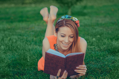 美丽的女孩读一本书在草