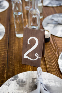 餐桌上的婚礼上有食物和鲜花。数字2写在白色卡片站立在花束之前在餐桌的中心