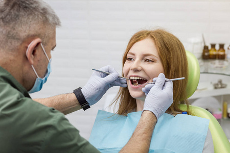 牙医在诊所检查女孩的牙齿。牙科问题。健康的微笑