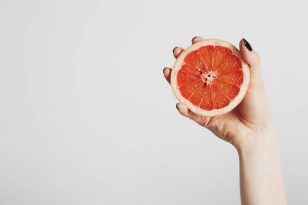 手里拿着一片鲜橙。在具有文本复制空间的背景上隔离。清洁饮食概念