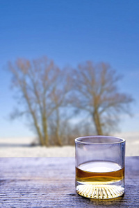 玻璃与威士忌在窗台和冬天风景在背景上