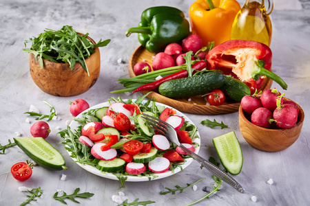创意新鲜蔬菜沙拉与 ruccola, 黄瓜, 西红柿和 raddish 在白色板材, 选择性重点