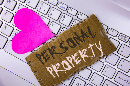 文字书写个人财产。财产财产的商业概念私人个人所有者写在撕纸板片上放在笔记本粉红色的心脏旁边