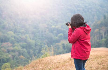 年轻女子摄影师拍摄森林图片图片