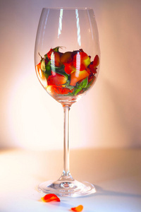 玻璃花瓶充满了红色的玫瑰花瓣。芳香疗法的概念