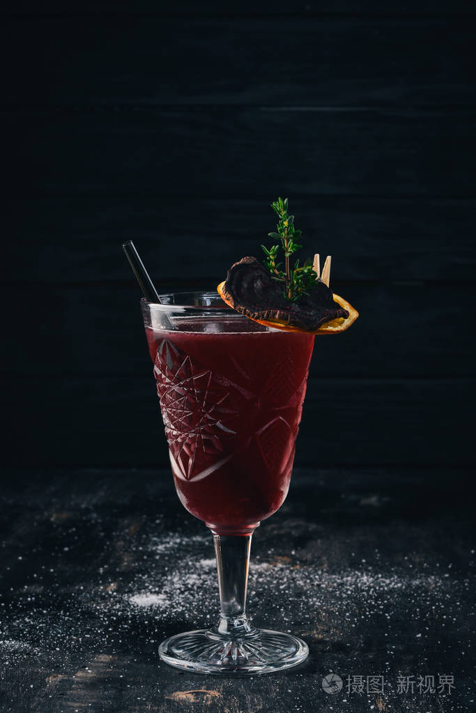 酒精鸡尾酒.朗姆酒, 桃酒, 樱桃汁.在黑色的木质背景上