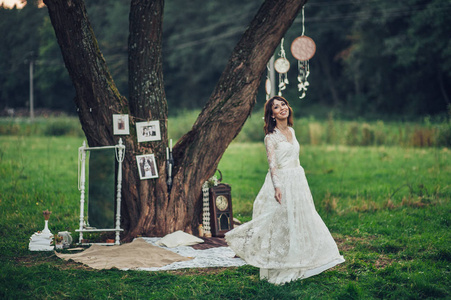 美丽的高加索新娘穿着婚纱摆在树前的 dreamcatchers