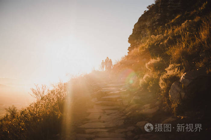 人们在阳光明媚的日子里徒步登山