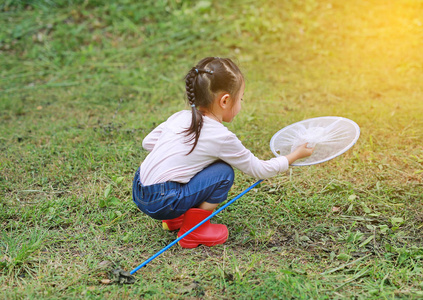 可爱的小亚洲女孩夏天在昆虫网地里戴草帽