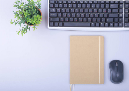 现代办公桌用键盘电话笔记本上的白色背景顶部视图模拟。复制空间