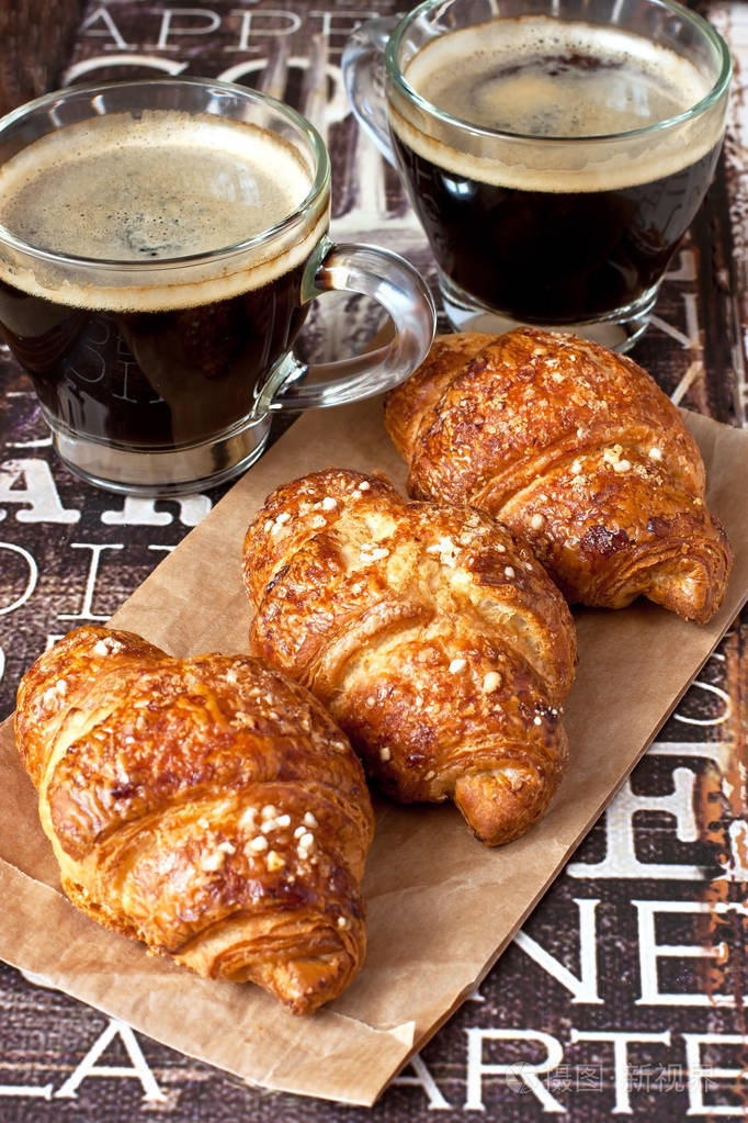 咖啡和木制背景上的牛角面包