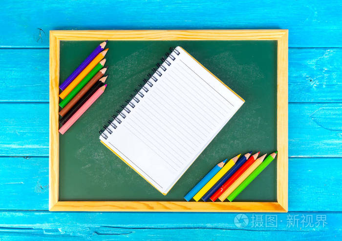 在蓝色背景下关闭铅笔颜色书和粉笔板的排列学前教育回到学校和复制