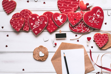 装饰成分与手工红色釉面饼干, 信件, 纸和铅笔在木木板背景专门为情人节