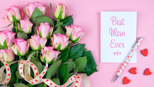 母亲每天开销玫瑰, 最好的妈妈永远贺卡和礼物在粉红色的桌子上