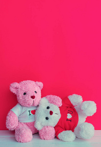 熊娃娃在木木板桌面上与红色粉红色的背景, 情人节的概念