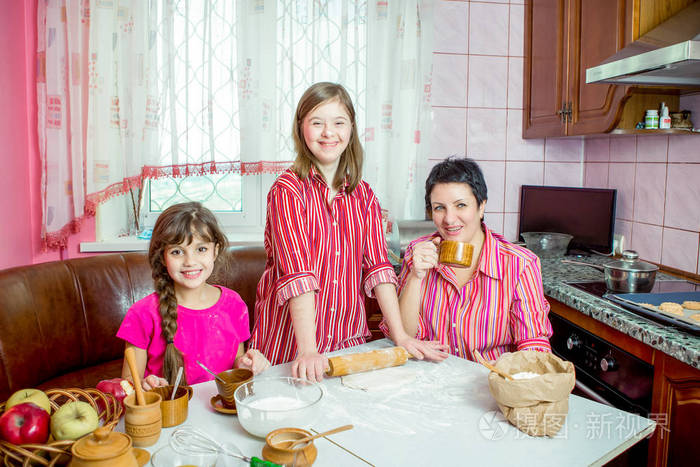 妈妈教她的两个女儿在厨房做饭