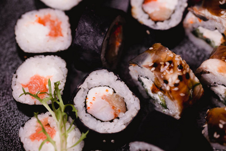 特写寿司握和卷在棕色木桌在板材被提供。健康的亚洲食品。宏观摄影
