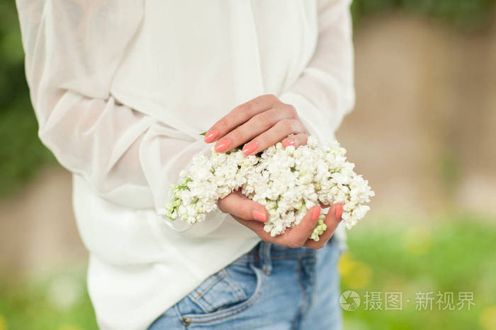 女人手捧着白丁香花盛开在她的手中, 可用作背景