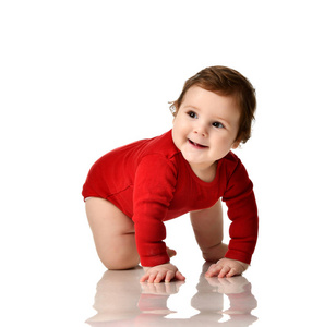 婴孩孩子孩子在红色身体布料学习爬行快乐微笑