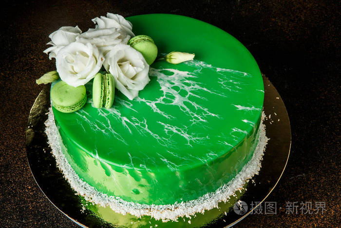 用白玫瑰和薄荷杏仁装饰的釉慕斯绿蛋糕