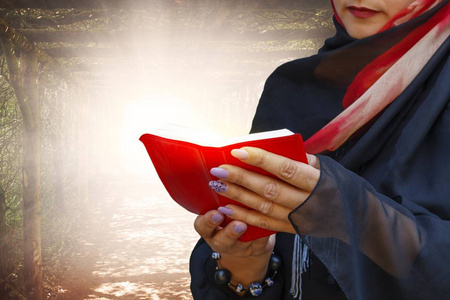对上帝无信仰圣经里的女人.年轻的穆斯林妇女与书.手里拿着祈祷书.