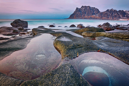 美丽的日落挪威海岸冰冷的北极海滩上风景如画的石头景观